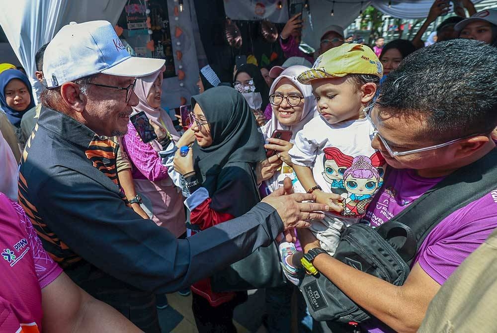 Perdana Menteri, Datuk Seri Anwar Ibrahim beramah mesra dengan pengunjung pada sambutan November Bulan Keluarga Kebangsaan bertemakan "Keluarga Harmoni, Negara Madani" di Dataran Putrajaya pada Sabtu. - Foto Bernama