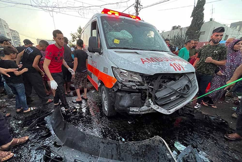 Penduduk Palestin memeriksa kerosakan selepas konvoi ambulans diserang di pintu masuk hospital Shifa di Bandar Gaza, 3 November 2023. -Gambar fail/Reuters