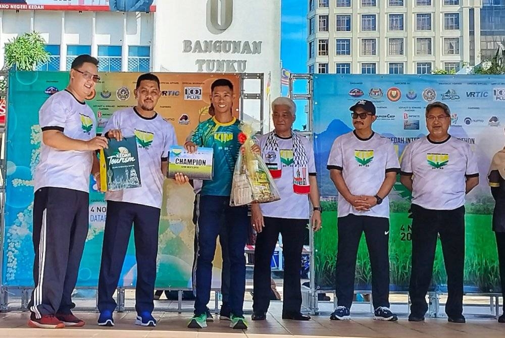 Muhamad Radhi (dua dari kiri) menyampaikan hadiah kepada pemenang Program Maraton Antarabangsa Kedah di Dataran Pekan Rabu pada Sabtu.