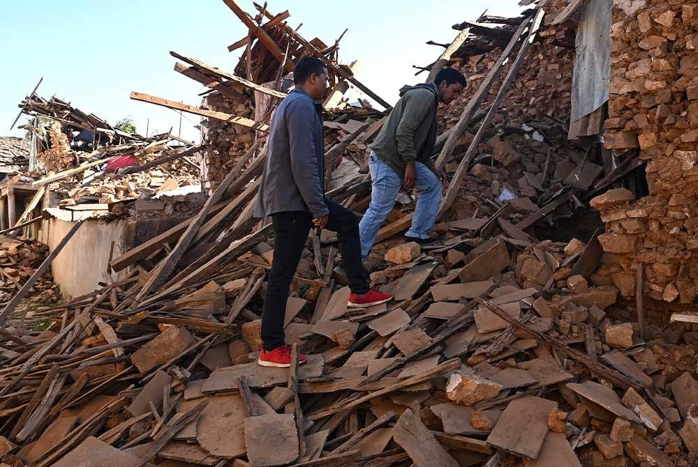 Penduduk memeriksa rumah yang runtuh di daerah Jaharkot, Nepal. - Foto AFP