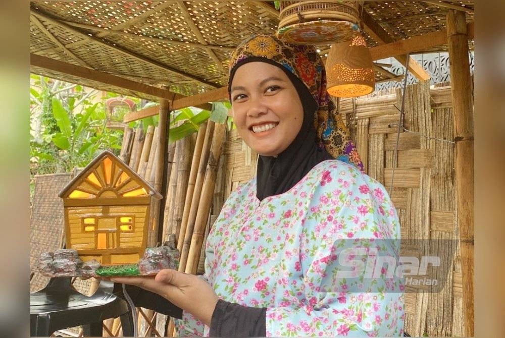 Nur Syazwani Izyan menunjukkan hiasan lampu yang dihasilkan daripada tanah liat.