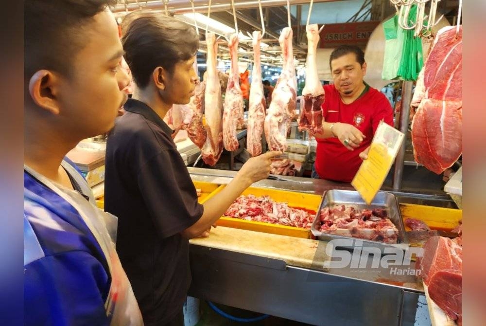 Suhaimi menunjukkan kepada pekerjanya mengenai notis yang melarang penggunaan wang palsu di gerainya.