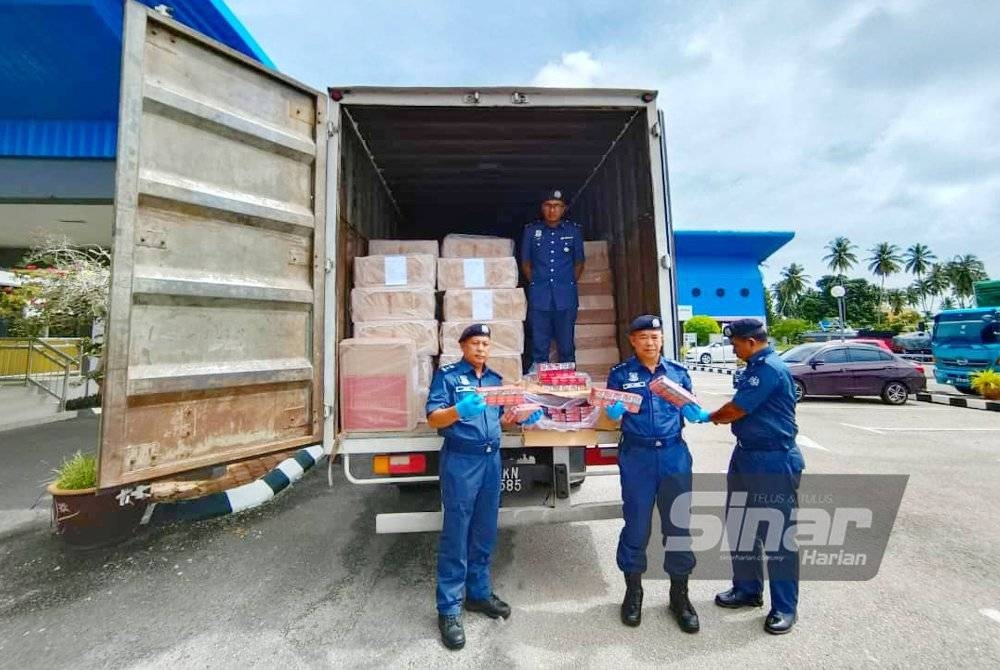 Wan Jamal Abdul Salam (dua dari kanan) menunjukkan lori bonded yang digunakan untuk menyeludup rokok dari Kelantan ke Lembah Klang.