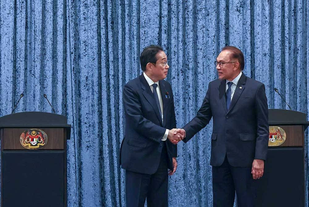 Anwar (kanan) bersalaman bersama rakan sejawatnya dari Jepun, Fumio Kishida pada sidang media bersama di Seri Perdana hari ini. - Foto Bernama