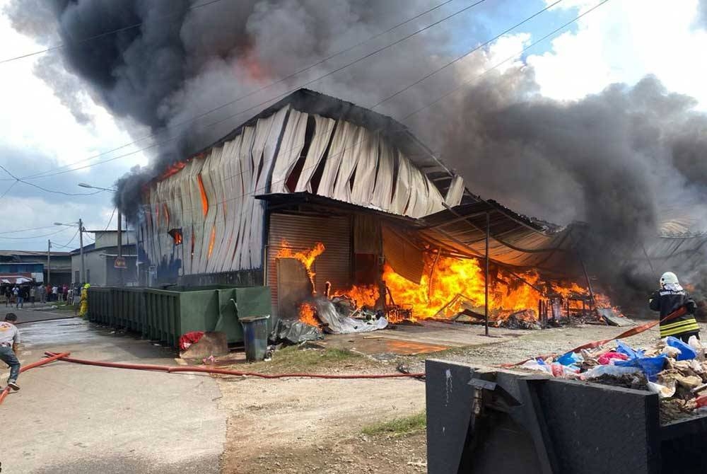 Anggota Bomba dan Penyelamat sedang memadamkan kebakaran kilang perabot di Kampung Kerdas 4, di sini, pada Isnin.