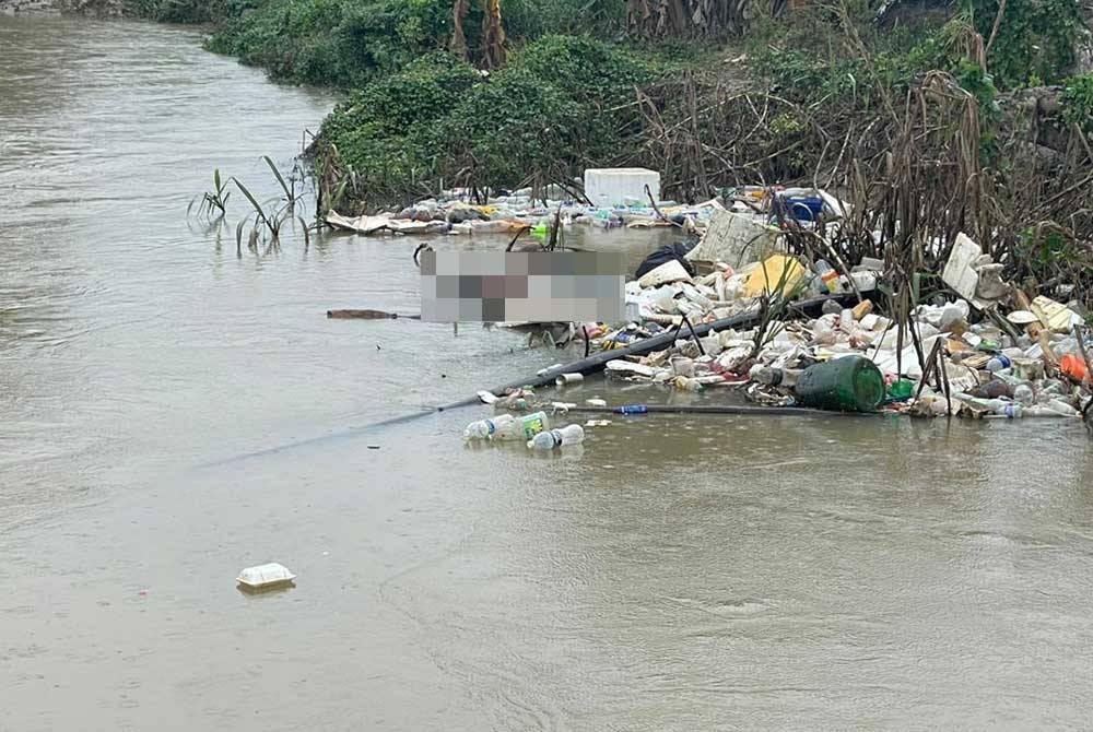 Mayat seorang lelaki warga tempatan ditemui tersangkut dalam longgokan sampah di tebing Sungai Kinta dekat Malim Nawar pada Ahad. - Foto: Pembaca