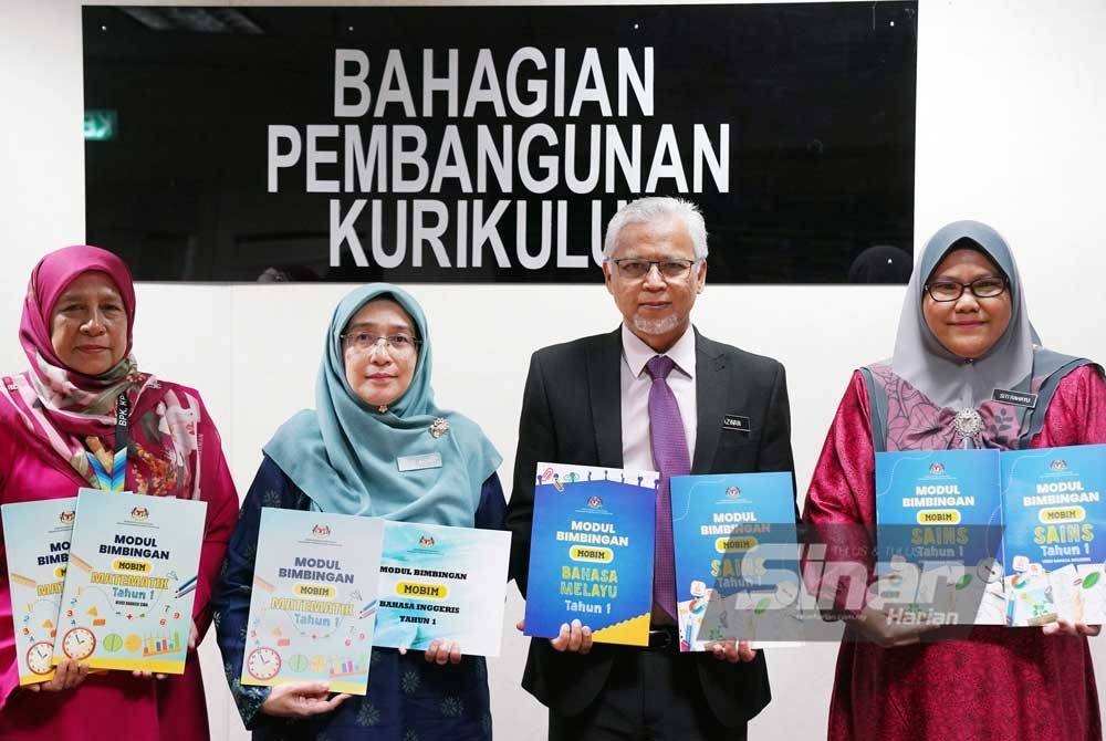 Timbalan Pengarah Sektor Dasar Dan Penyelidikan Kurikulum, Dr Azwan Abd Aziz (dua dari kanan) bersama Nor&#039;aidah (dua dari kiri) menunjukkan MOBIM Tahun Satu yang memanfaatkan guru dalam merancang PdP. - Foto SINAR HARIAN/ROSLI TALIB