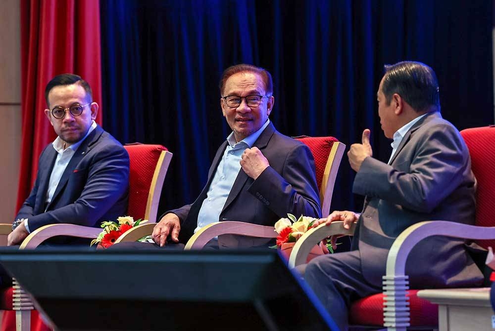 Anwar (tengah) bersama Timbalan Menteri Kewangan, Datuk Seri Ahmad Maslan (kanan) dan Steven Sim Chee Keong semasa majlis Perhimpunan Warga Kementerian Kewangan hari ini. - Foto Bernama