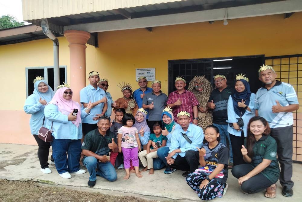 Ithnin (berdiri, enam dari kiri) dan Muhammad Nasir (berdiri, enam dari kanan) selepas perasmian program penyediaan kemudahan capaian internet dan Wi-Fi di Kampung Orang Asli Sungai Bumbun.