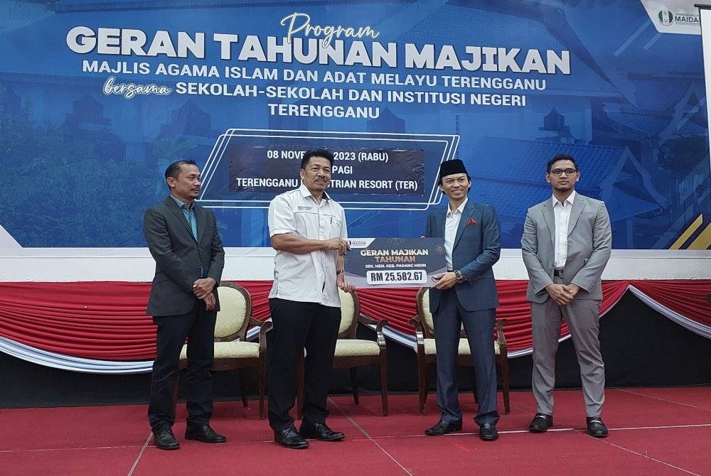 Dr Ahmad Azrin (dua dari kanan) serahkan geran kepada salah seorang penerima pada Program Tahunan Majikan MAIDAM