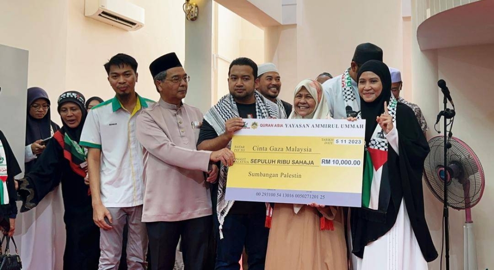 Ogy bersama adik pengasas Yayasan Ammirul Ummah, Ahmad Ibrahim Ridhwan Ismail @ Omar (kiri) menyampaikan replika cek kepada Cinta Gaza Malaysia.