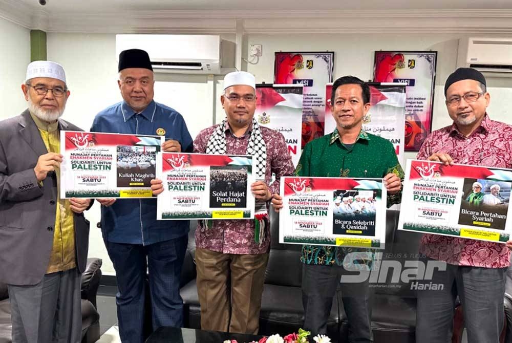 Mohd Asri (tengah) menunjukkan risalah mengajak orang ramai menyertai Himpunan Munajat Pertahan Enakmen Syariah dan Solidariti Untuk Palestin yang akan diadakan di Stadium Sultan Muhammad IV, Kota Bharu.