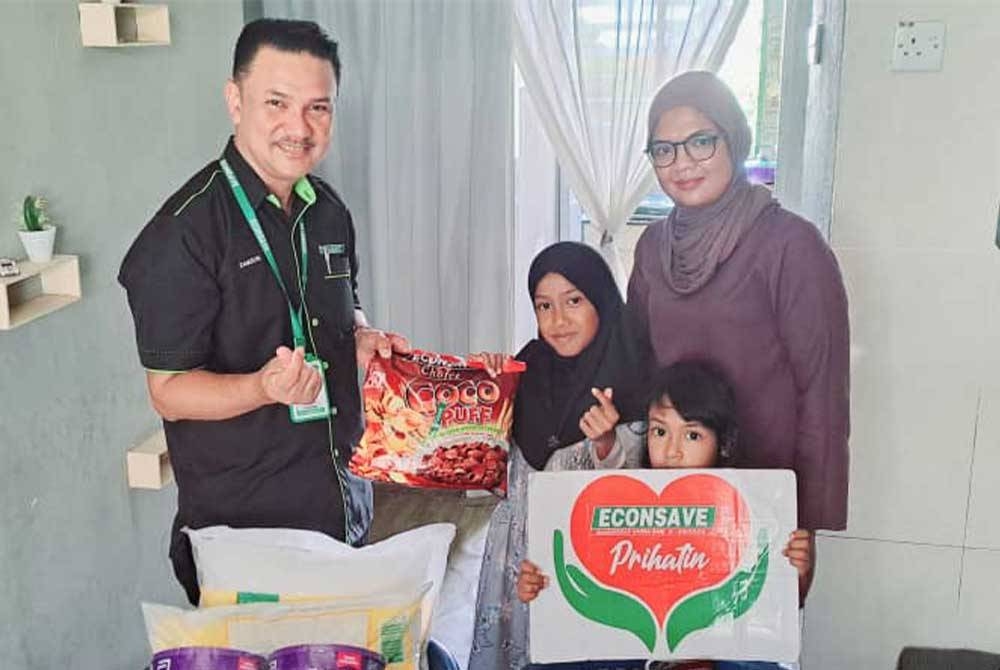 Zamzuri (kiri) hadir menyerahkan sumbangan Econsave Prihatin kepada dua beradik yang hidap penyakit kronik di Taman Sri Tandop, Jalan Simpang Empat, Alor Setar.