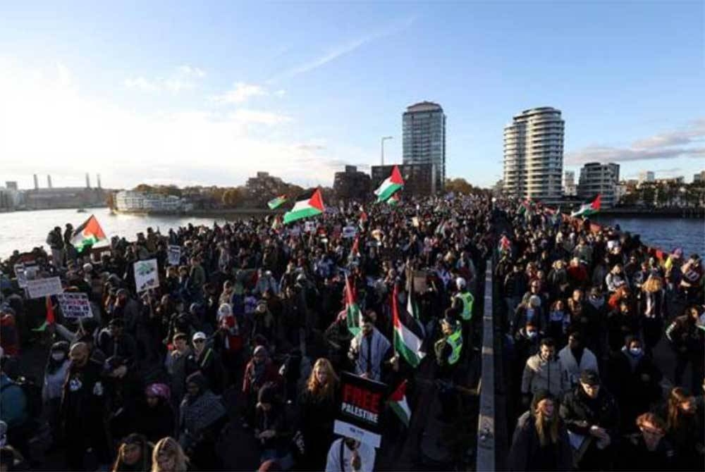 Peserta perhimpunan pro-Palestin berarak di Jambatan Vauxhall, London pada Sabtu sebagai menunjukkan rasa simpati dan sokongan kepada masyarakat Palestin yang berhadapan kekejaman Israel. – Foto Reuters.