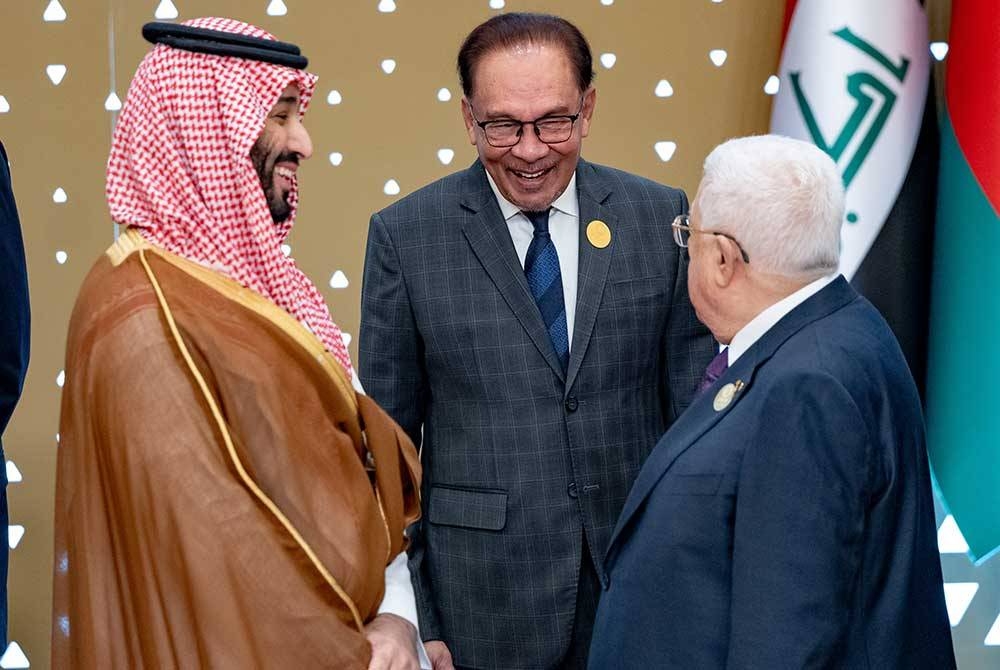 Perdana Menteri Datuk Seri Anwar Ibrahim beramah mesra bersama Putera Mahkota Arab Saudi Mohammed Bin Salman (kiri) dan Presiden Palestin Mahmoud Abbas (kanan) pada Sidang Media Kemuncak Tergempar Pertubuhan Kerjasama Islam (OIC) kali Kelapan di Riyadh Arab Saudi pada Sabtu. - Foto Bernama.