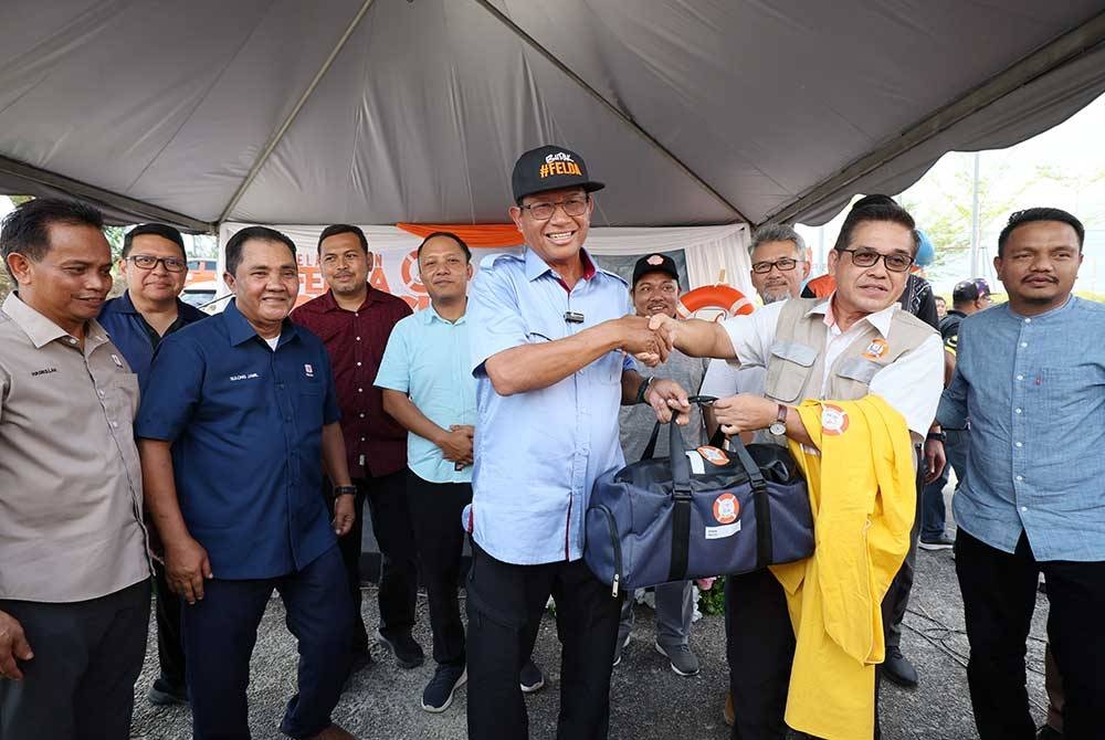 Ahmad Shabery menyerahkan kit kesiapsiagaan banjir kepada setiap Pengurus Besar Felda Wilayah sempena majlis pelancaran program Felda Siap Siaga 2023 di Dewan Serbaguna Felda Seberang Tayor di Kemaman.