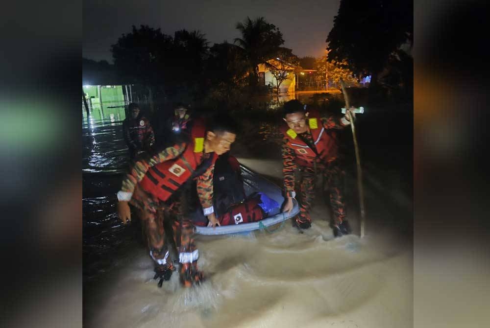 Anggota bomba membantu memindahkan penduduk terjejas banjir di Lorong Damai 8, Kampung Sentosa Damai Pasir Gudang.- Foto: Bomba