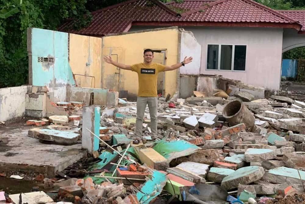 Azmeer bergambar di atas tanah yang dibelinya untuk membina rumah sewa lima pintu.