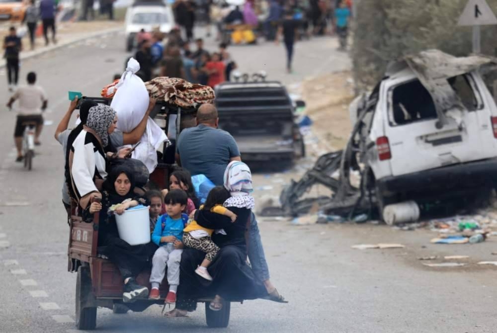 Penduduk Palestin tiba di selatan Kota Gaza pada Ahad, selepas meninggalkan rumah mereka di Bandar Gaza dan Semenanjung Gaza utara. - Foto AFP