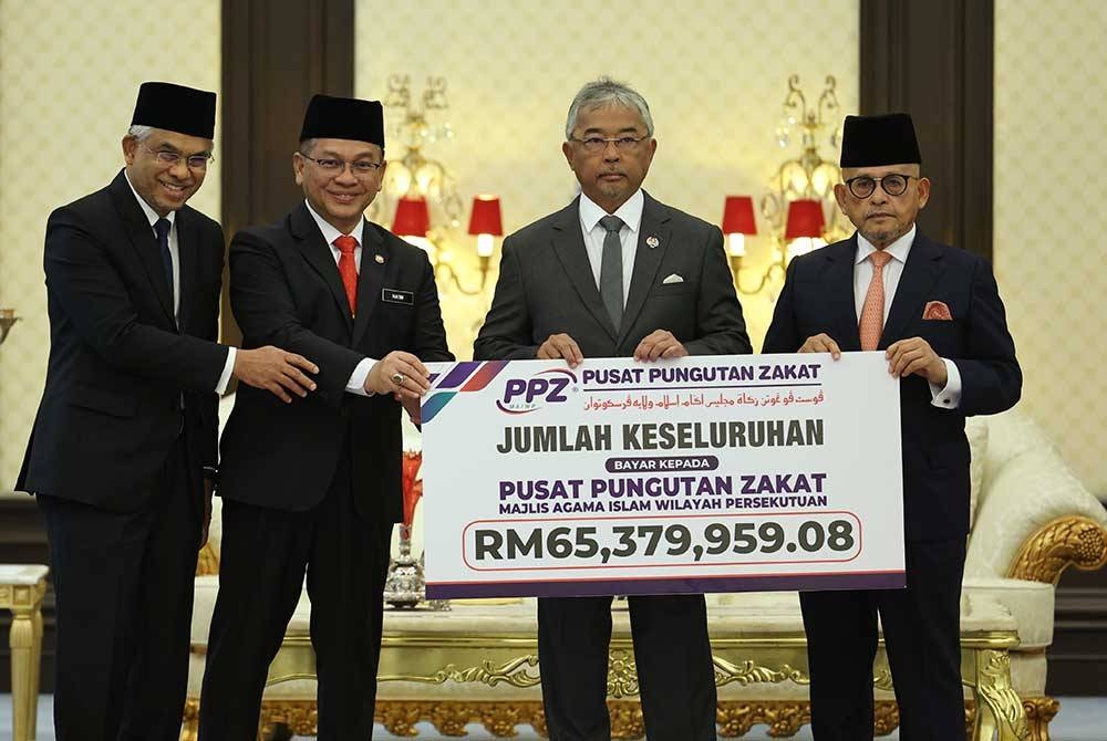 Al-Sultan Abdullah berkenan menerima bayaran zakat perniagaan berjumlah RM65,379,959.08 daripada Abdul Aziz (kanan) bagi pihak PPZ-MAIWP dalam Majlis Zakat Korporat PPZ-MAIWP di Istana Negara hari ini. - Foto Bernama