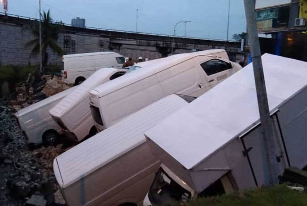 Enam van dan sebuah lori terjejas akibat mendapan tanah di kawasan tempat letak kenderaan MBSJ, Bandar Puchong, dekat sini dalam kejadian petang Isnin. - Foto ihsan bomba