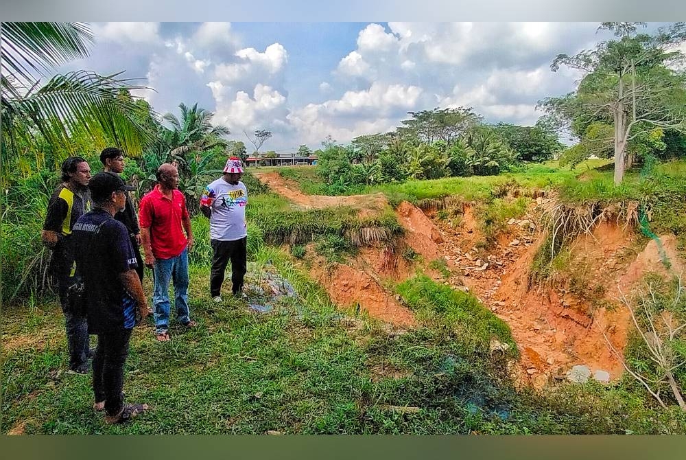 Penduduk Taman Lipat Kajang Perdana melihat runtuhan tanah yang berlaku berhampiran Jalan LKP8.