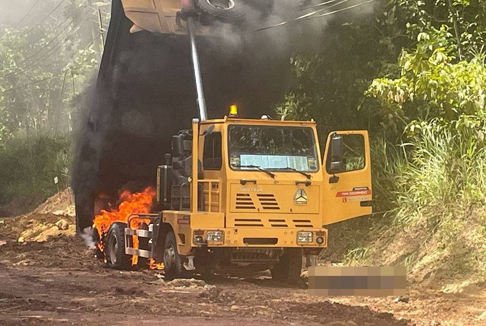 Lori yang sedang menurunkan muatan tanah terbakar selepas terkena kabel elektrik dalam kejadian di Kampung Samparita, Kota Marudu.