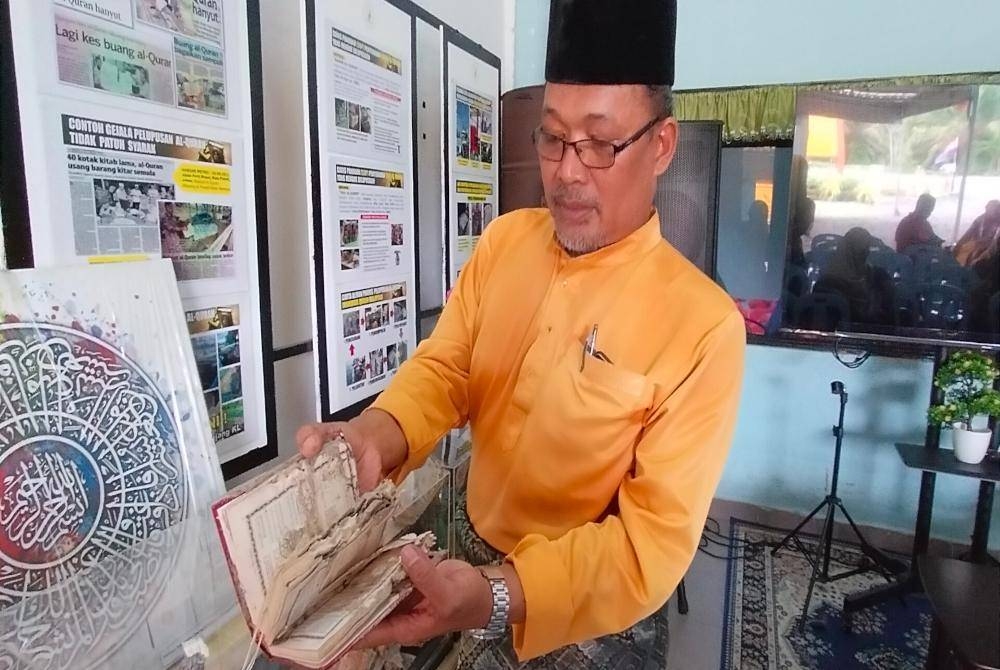 
Fadzli menunjukkan al-Quran yang rosak akibat dimakan anai-anai.