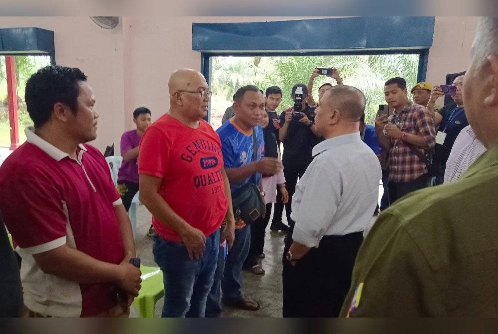 Saarani (tengah) melawat mangsa banjir yang ditempatkan di PPS Dewan Serbaguna Chikus, Teluk Intan pada Rabu.