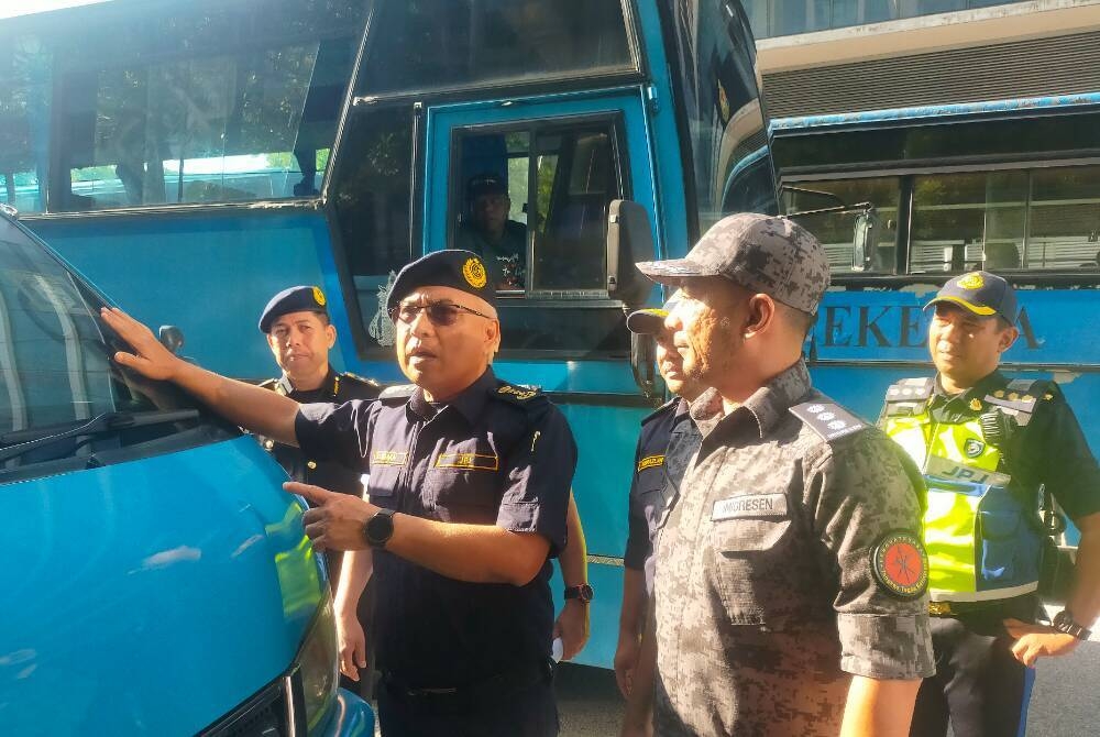 Lokman (kiri) melihat cukai jalan sebuah kenderaan komersial yang ditahan semasa Operasi Khas Bersepadu Kenderaan Perkhidmatan Awam oleh JPJ dan JIM di Putrajaya pada Khamis.