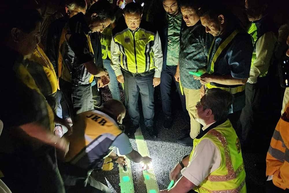 Alexander (tengah) mendengar penerangan penggunaan cat &#039;glow in the dark&#039; di Jalan Sungai Lalang. - Foto FB Sany Hamzan.