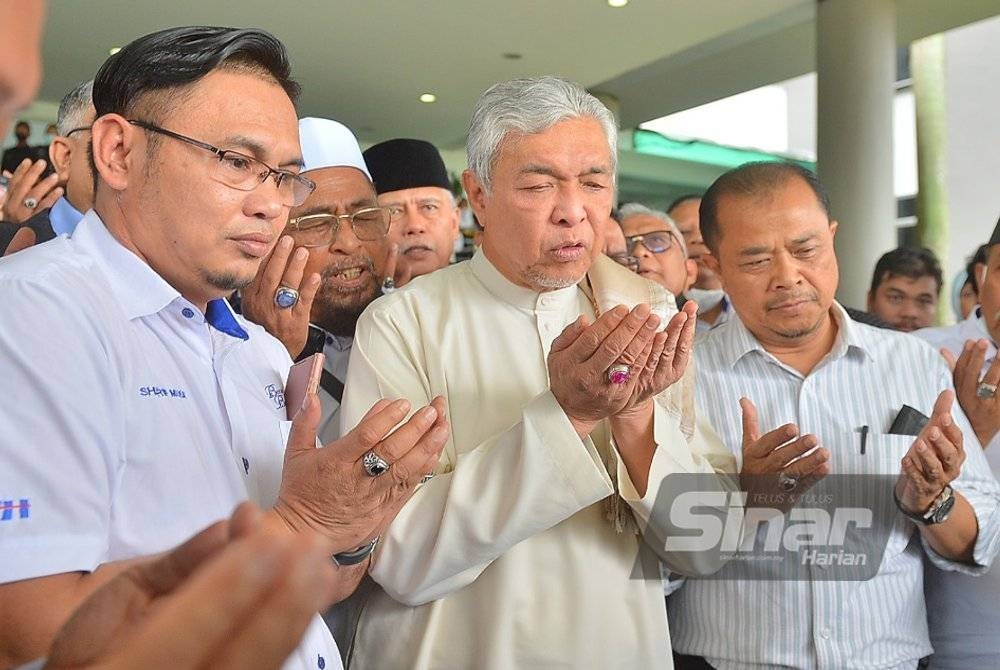 Ahmad Zahid (tengah) menadahkan tangan berdoa mengucap syukur selepas dibebaskan atas 40 pertuduhan rasuah berhubung VLN di Mahkamah Tinggi Shah Alam, 23 September tahun lalu. - Foto Sinar Harian ROSLI TALIB