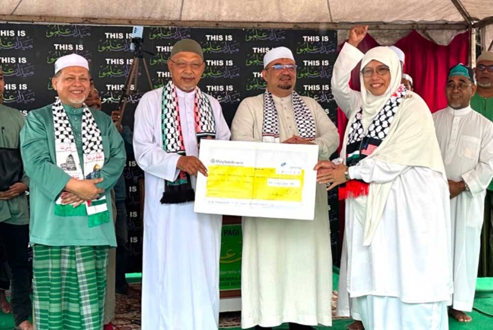 Simbolik penyerahan replika cek atas sumbangan kepada Palestin bagi membantu umat Islam yang terjejas.