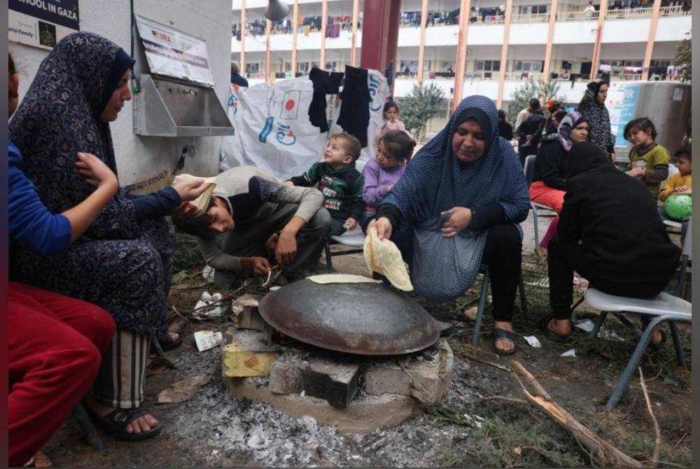 Wanita Palestin menyediakan roti sebagai makanan. - Foto AFP