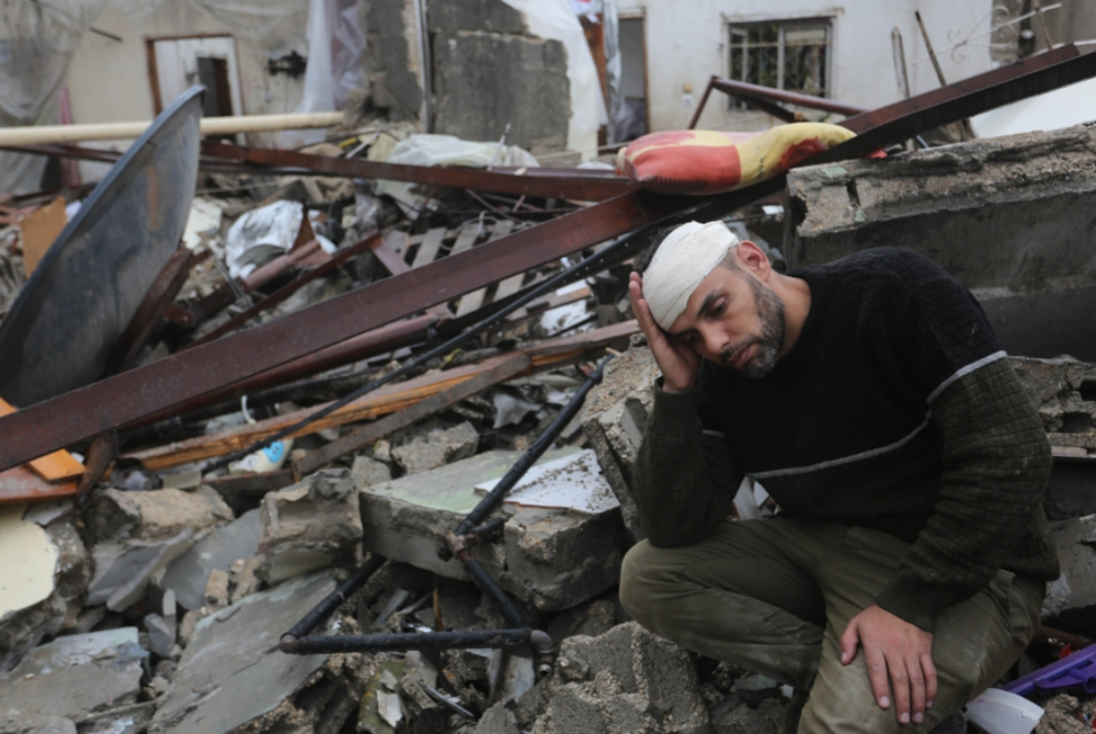 Seorang lelaki duduk di antara runtuhan bangunan yang musnah dalam serangan udara Israel di bandar Rafah, selatan Semenanjung Gaza. - Foto Xinhua