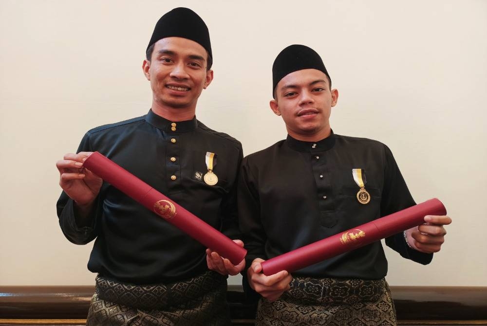 Muhd Shafiq (kiri) dan Mohamad Rifdean menerima penganugerahan PJK pada sesi kedua Istiadat Penganugerahan Darjah Kebesaran dan Pingat Negeri Perak di Balairong Seri Istana Iskandariah, Kuala Kangsar pada Sabtu.