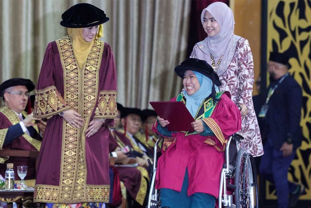 Permaisuri Johor yang juga Canselor Universiti Teknologi Malaysia (UTM) Raja Zarith Sofiah Almarhum Sultan Idris Shah (kiri) berkenan menyampaikan skrol kepada penerima Ijazah Doktor Falsafah Siti Fatimah Mohd Shahar (duduk, kanan) pada Majlis Konvokesyen UTM ke-67 di Skudai pada Sabtu - Foto Bernama.