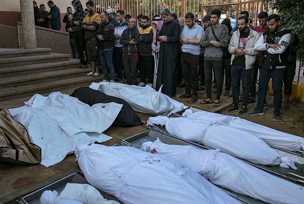 Warga Palestin menunaikan solat jenazah ke atas sejumlah mangsa yang terkorban dalam serangan yang dilancarkan tentera Zionis Israel. - Foto EPA