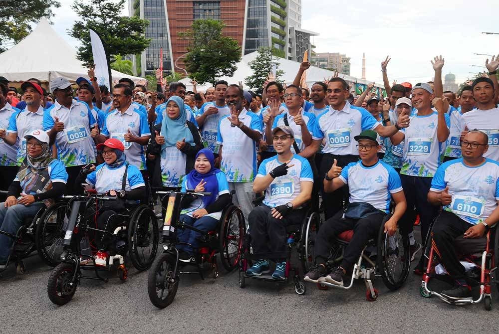 Sivakumar (tengah) bergambar kenangan bersama sebahagian para peserta pada Majlis Pelepasan Perkeso Run & Ride 2023 di Dataran Wawasan, Persiaran Perdana, Presint 2, pada Ahad. - Foto Bernama