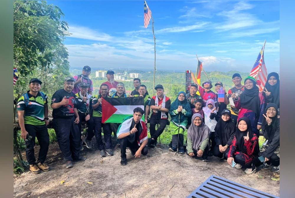 
Peserta mendaki Bukit Melati sambil membawa bendera Palestin.