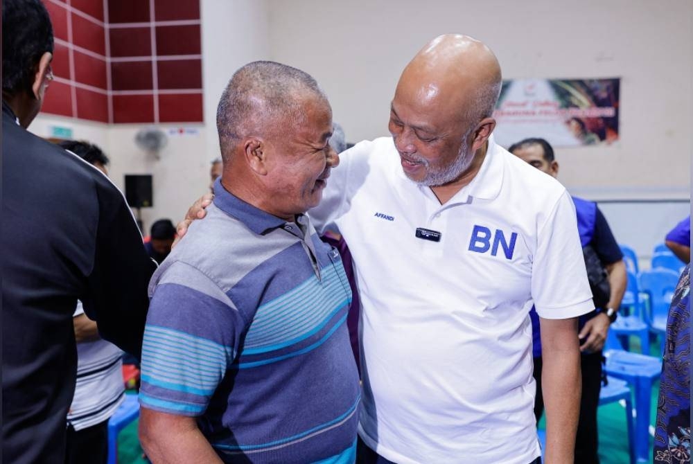 
Raja Mohamed Affandi (kanan) beramah mesra bersama penyokong yang hadir semasa berkempen di Felda Neram 01 sempena PRK Kemaman pada Sabtu. - Foto Bernama