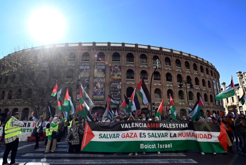 Orang ramai memegang sepanduk bertulis "Valencia bersama Palestin. Menyelamatkan Gaza adalah menyelamatkan Kemanusiaan. Boikot Israel" mengambil bahagian dalam tunjuk perasaan menyokong rakyat Palestin di Valencia pada Ahad. - Foto JOSE JORDAN/AFP