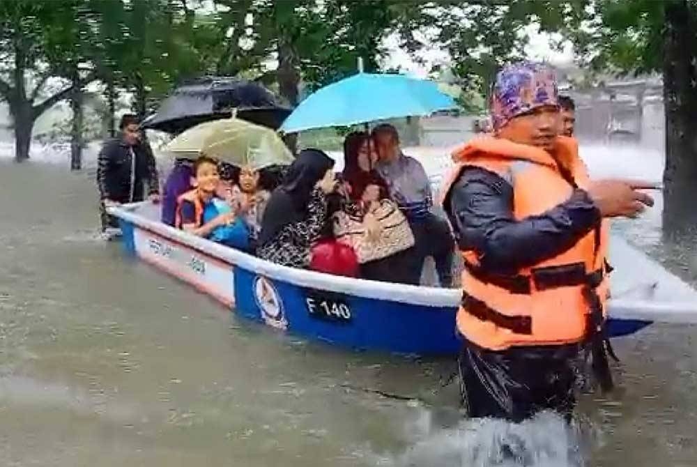 Anggota penyelamat membantu memindahkan penduduk terjejas di padang SK Padang Negara, Kuala Terengganu. - Foto Ihsan Angkatan Pertahanan Awam Malaysia (APM)