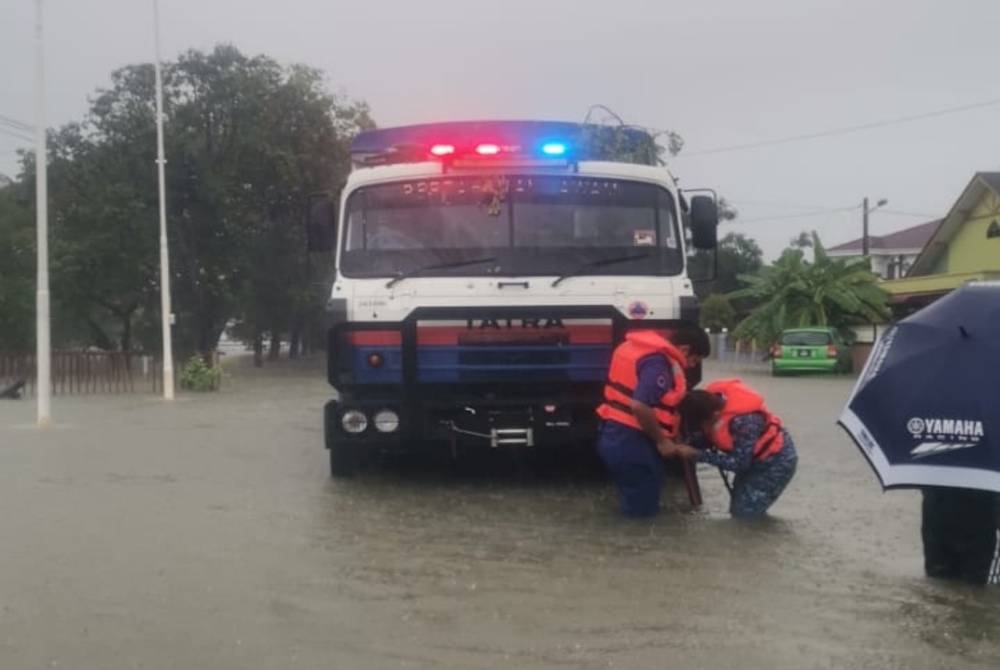 Anggota penyelamat berusaha memindahkan mangsa banjir di Kampung Gong Pak Maseh di Kuala Terengganu. - Foto APM