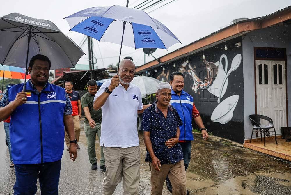 Raja Mohamed Affandi(tengah) bertemu bersama para pengundi di PDM Kampung Chabang sempena kempen PRK Parlimen Kemaman, pada Isnin. - Foto Bernama