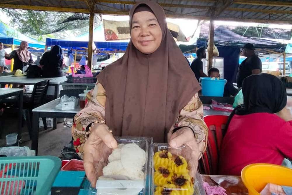 Zamariah menunjukkan kuih bekang (kiri) dan qasidah di gerainya di Pasar Besar Chukai, Kemaman.