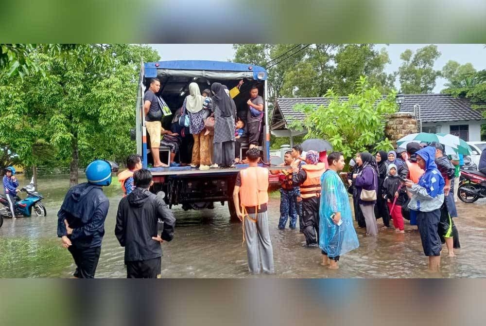 Anggota penyelamat membantu memindahkan mangsa yang terjejas banjir. - Foto APM