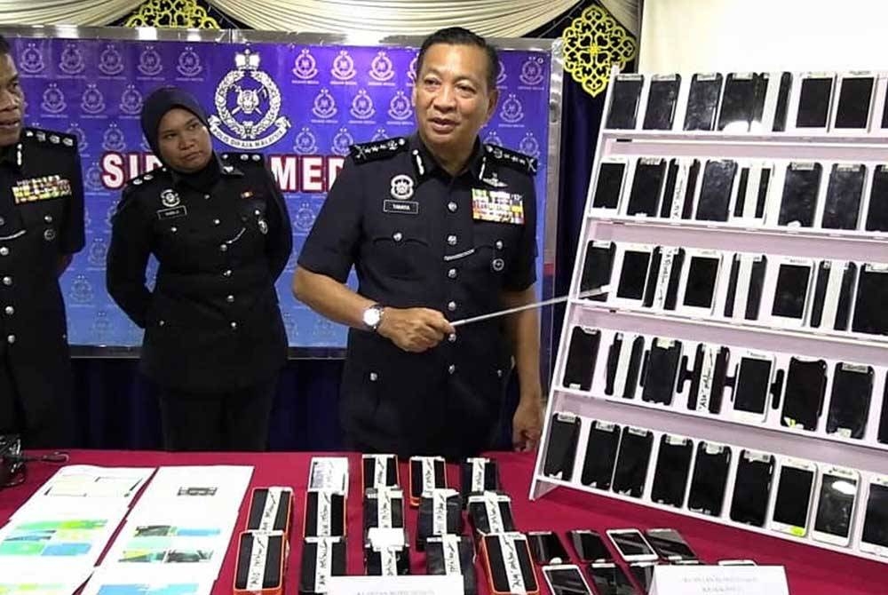 Yahaya menunjukkan telefon bimbit yang digunakan oleh sindiket terbabit pada sidang akhbar di IPD Kuantan pada Selasa.