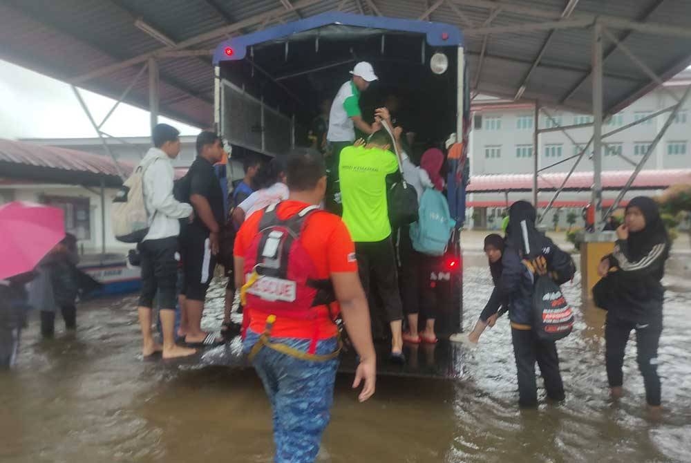 Anggota penyelamat membantu memindahkan penduduk yang terjejas banjir. - Foto Angkatan Pertahanan Awam Malaysia (APM)