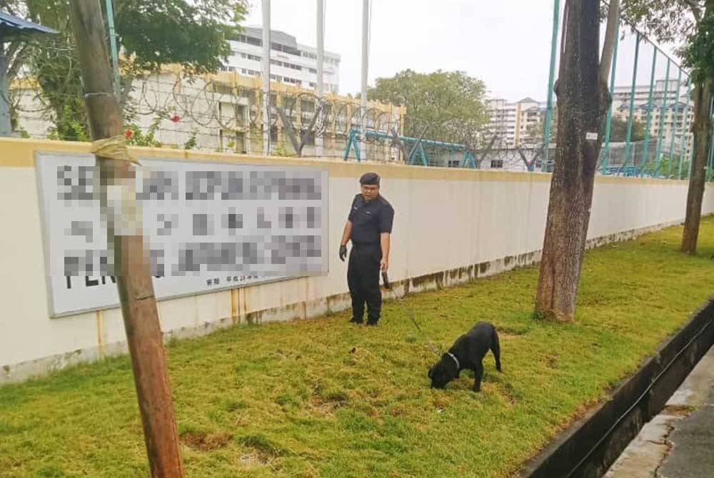 Anjing K9 digunakan bagi melakukan pemeriksaan di salah sebuah sekolah yang menerima ancaman bom pada Selasa.